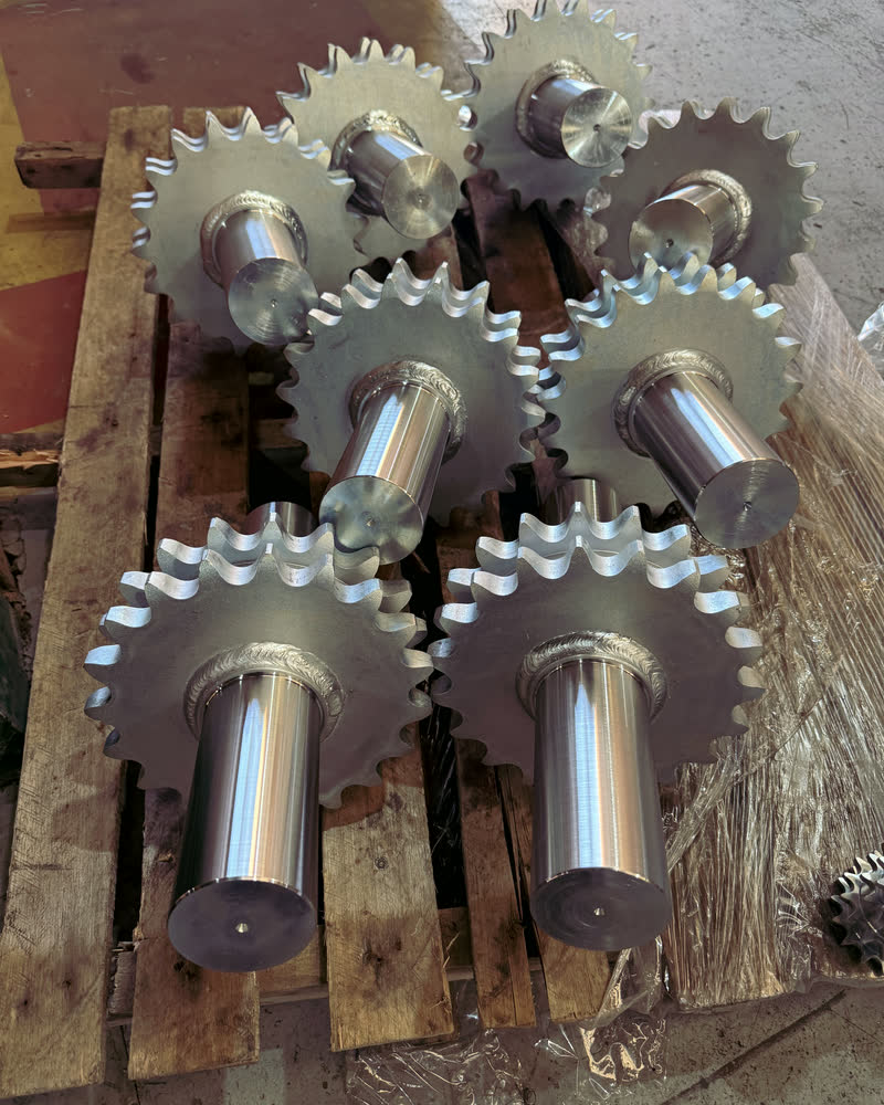 Rodas dentadas com cubos usinados, agrupadas sobre palete de madeira